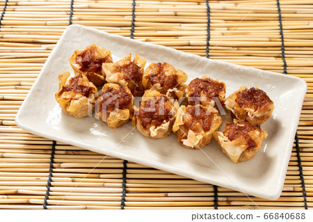 炒熟麥放在盤子上。背景，百葉窗。 66840688