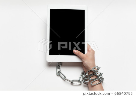 Close up of human hand using tablet with blank black screen. Tied with chain, addiction Close up of human hand using tablet with blank black screen. Tied with chain, addiction 66840795