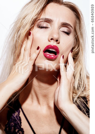 emotions and feelings concept - beautiful blond lady portrait in sexy lingerie while getting an orgasm on white background. Woman shouts in ecstasy in bright light 66840989
