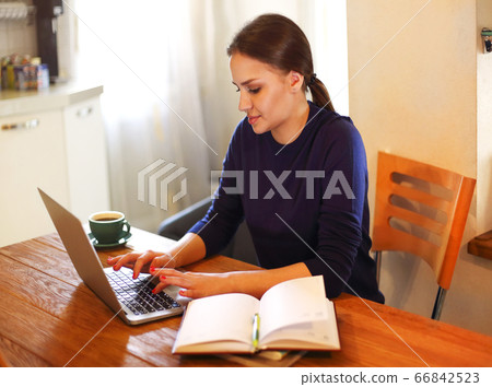 Brunette woman using laptop working at home Brunette woman using laptop working at home 66842523