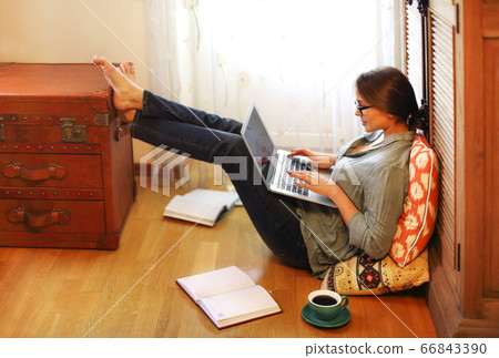 Woman designer using laptop on floor 66843390