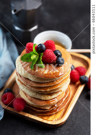 Pancakes with blueberries, raspberries, mint and honey for a breakfast Pancakes with blueberries, raspberries, mint and honey for a breakfast 66843511