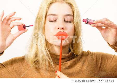 Woman applying lipstick or lip gloss 66843753