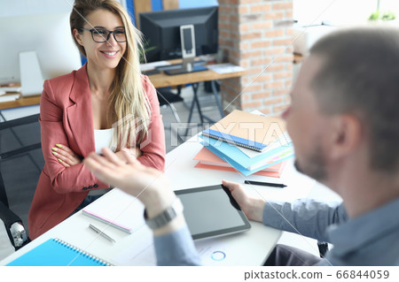 Businessman and woman talking against modern office background portrait 66844059