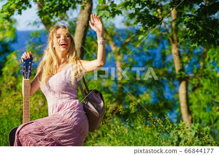 Girl with guitar outdoor on nature Girl with guitar outdoor on nature 66844177