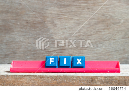 Tile letter on red rack in word fix on wood background 66844734