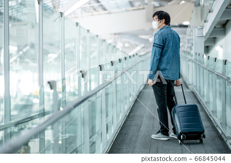 Asian man tourist wearing mask in airport terminal Asian man tourist wearing mask in airport terminal 66845044