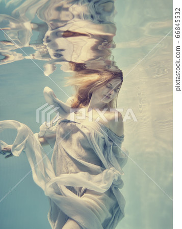Portrait of a girl in a blue dress floating underwater 66845532