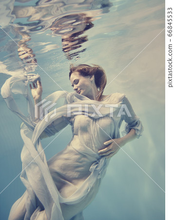 Portrait of a girl in a blue dress floating underwater 66845533