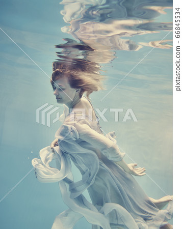 Portrait of a girl in a blue dress floating underwater 66845534