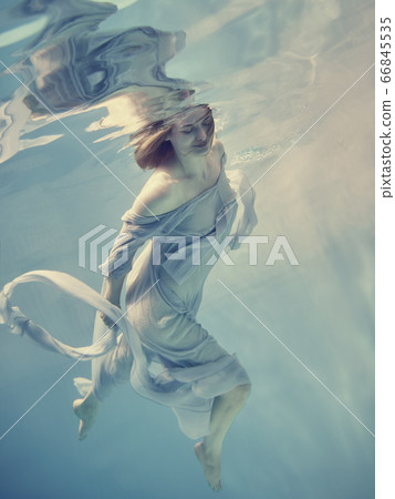 Portrait of a girl in a blue dress floating underwater 66845535
