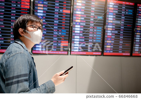 Asian man tourist wearing mask in airport terminal Asian man tourist wearing mask in airport terminal 66846668