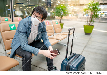 Asian man tourist wearing mask in airport terminal Asian man tourist wearing mask in airport terminal 66846675