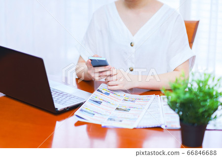 A young female general affairs man who arranges a business trip to a travel agency while watching a pamphlet [Lifestyle of after-corona] 66846688