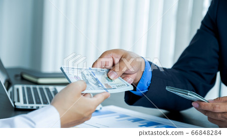 The businessman's hand in a suit is holding a The businessman's hand in a suit is holding a 66848284