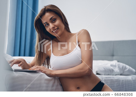 Attractive young woman using modern notebook at home 66848308