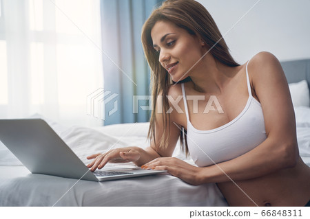 Charming young woman using modern notebook at home 66848311