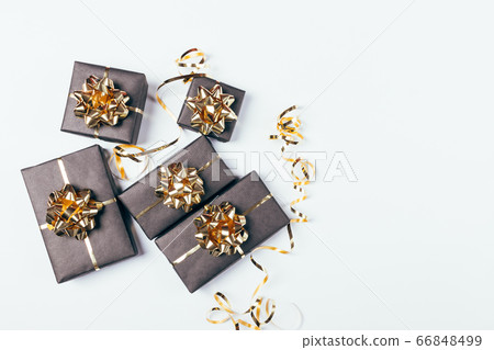 Festive black gift boxes with golden bows and 66848499