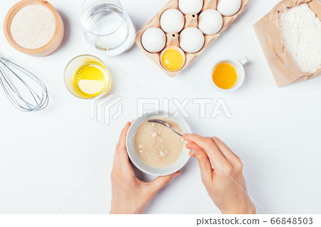 Top view female hands mix yeast with water Top view female hands mix yeast with water 66848503