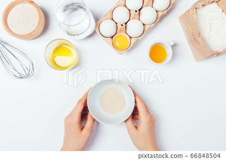Female hands holding bowl of dry active yeast 66848504