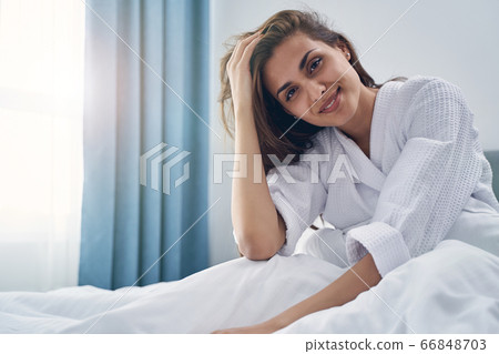 Beautiful young woman resting in bed at home 66848703
