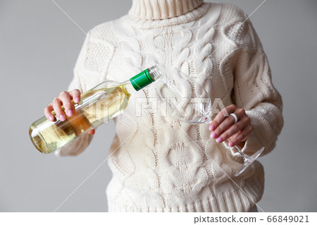 Female hands pour white wine from bottle to glass Female hands pour white wine from bottle to glass 66849021