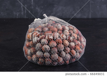Hazelnut net rests on black background 66849831