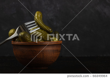 Gherkins and sauerkraut in a clay bowl on a dark Gherkins and sauerkraut in a clay bowl on a dark 66849964