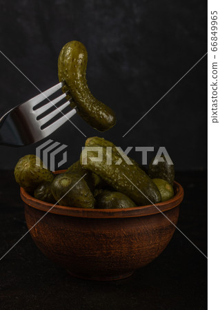 Gherkins and sauerkraut in a clay bowl on a dark Gherkins and sauerkraut in a clay bowl on a dark 66849965