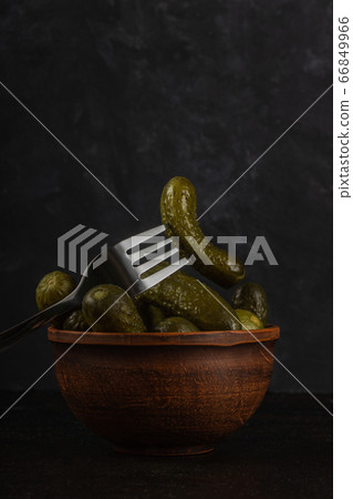 Gherkins and sauerkraut in a clay bowl on a dark Gherkins and sauerkraut in a clay bowl on a dark 66849966