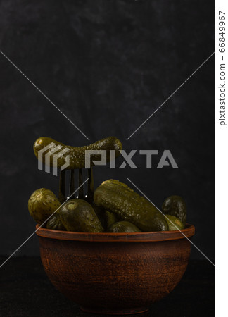Gherkins and sauerkraut in a clay bowl on a dark Gherkins and sauerkraut in a clay bowl on a dark 66849967