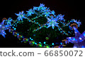 Fantastic whirling around stunning Christmas tree at town square decorated large luminous multi-pointed blue stars and yellow balls 66850072