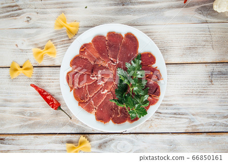Top view on sliced basturma slices with herbs Top view on sliced basturma slices with herbs 66850161