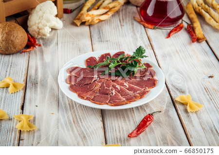 Top view on sliced basturma slices with herbs 66850175