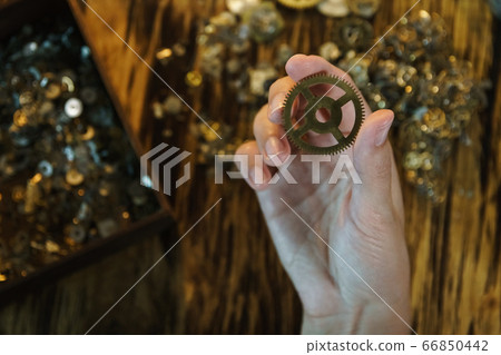 Woman watchmaker works with gears. 66850442