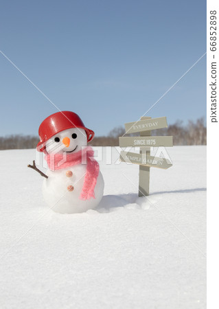 A resort information board and a snowman standing on a snowy field A resort information board and a snowman standing on a snowy field 66852898