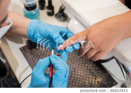 A manicurist manicures a girl. 66852915