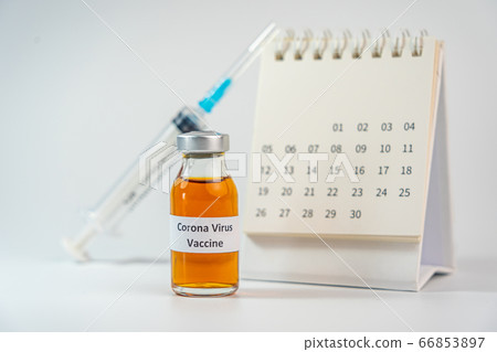 Coronavirus vaccine bottle and syringe injection next to 2020 calendar  66853897
