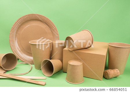 Tableware and packaging made of ecological materials on a green background. Tableware and packaging made of ecological materials on a green background. 66854051