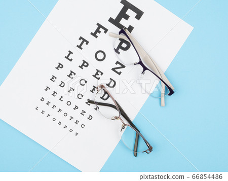 Two pairs of glasses for vision lie on the map optics on a blue background. 66854486