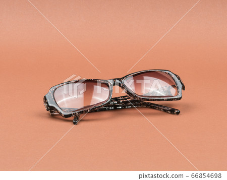 Tinted glasses on a brown background. The view from the top. Tinted glasses on a brown background. The view from the top. 66854698