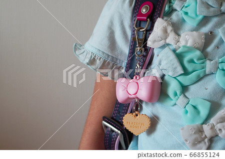 Cute security buzzer in the shape of a ribbon attached to a girl's school bag 66855124