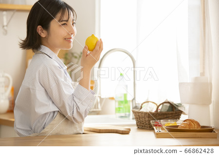 Young woman holding a lemon in her hand 66862428