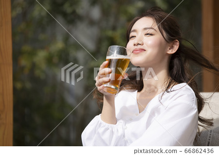 Woman drinking beer in a glass 66862436