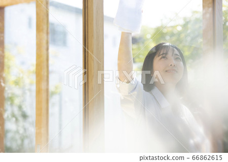 Young woman cleaning the window Young woman cleaning the window 66862615