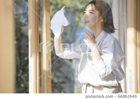 Young woman cleaning the window 66862649