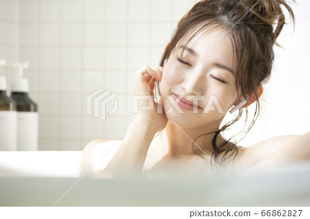 沐浴同時聽音樂的年輕女子 66862827