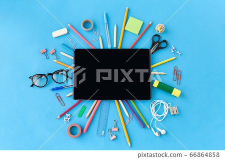 tablet pc and school supplies on blue background tablet pc and school supplies on blue background 66864858