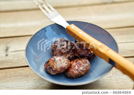 roasted meat cutlets on plate with barbeque fork roasted meat cutlets on plate with barbeque fork 66864869