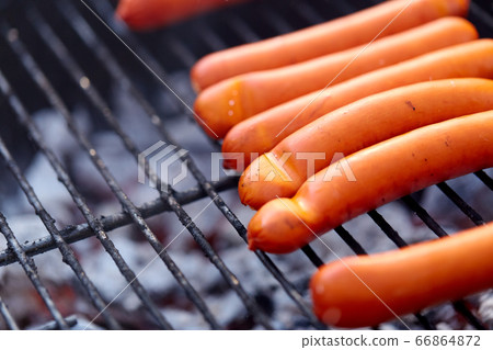 meat sausages roasting on hot brazier grill 66864872